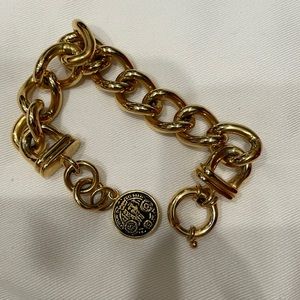 Gold statement bracelet with coin detail.